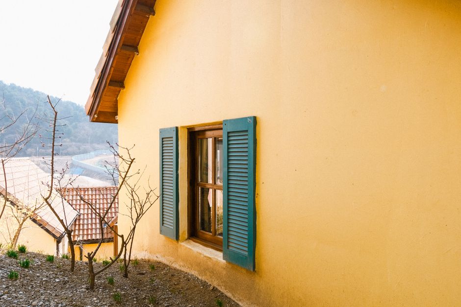 A yellow house with blue painted shutters.