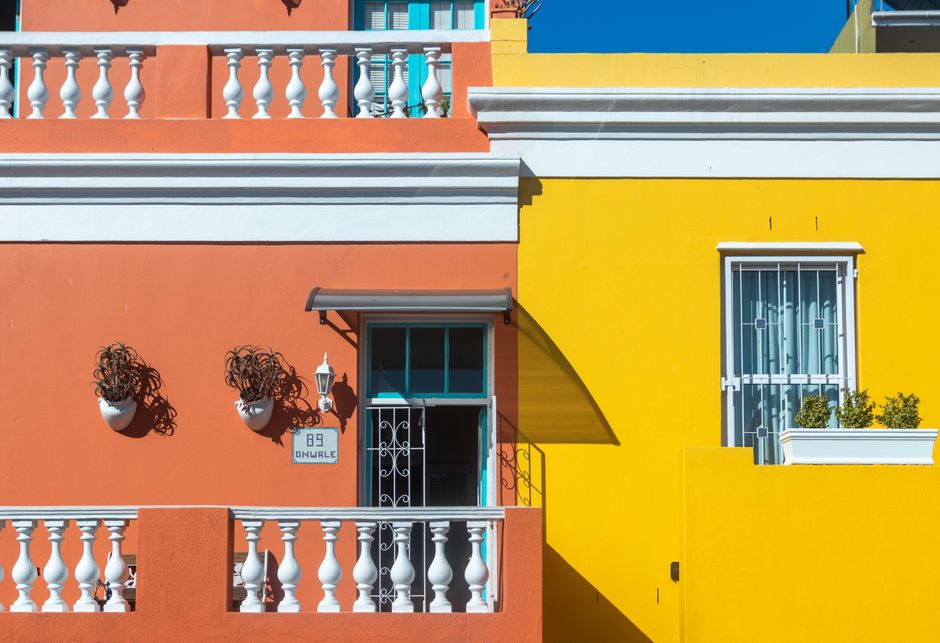 Row of houses with brightly painted orange and yellow exterior walls.