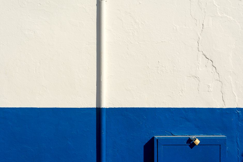A white and blue painted wall with a padlock.
